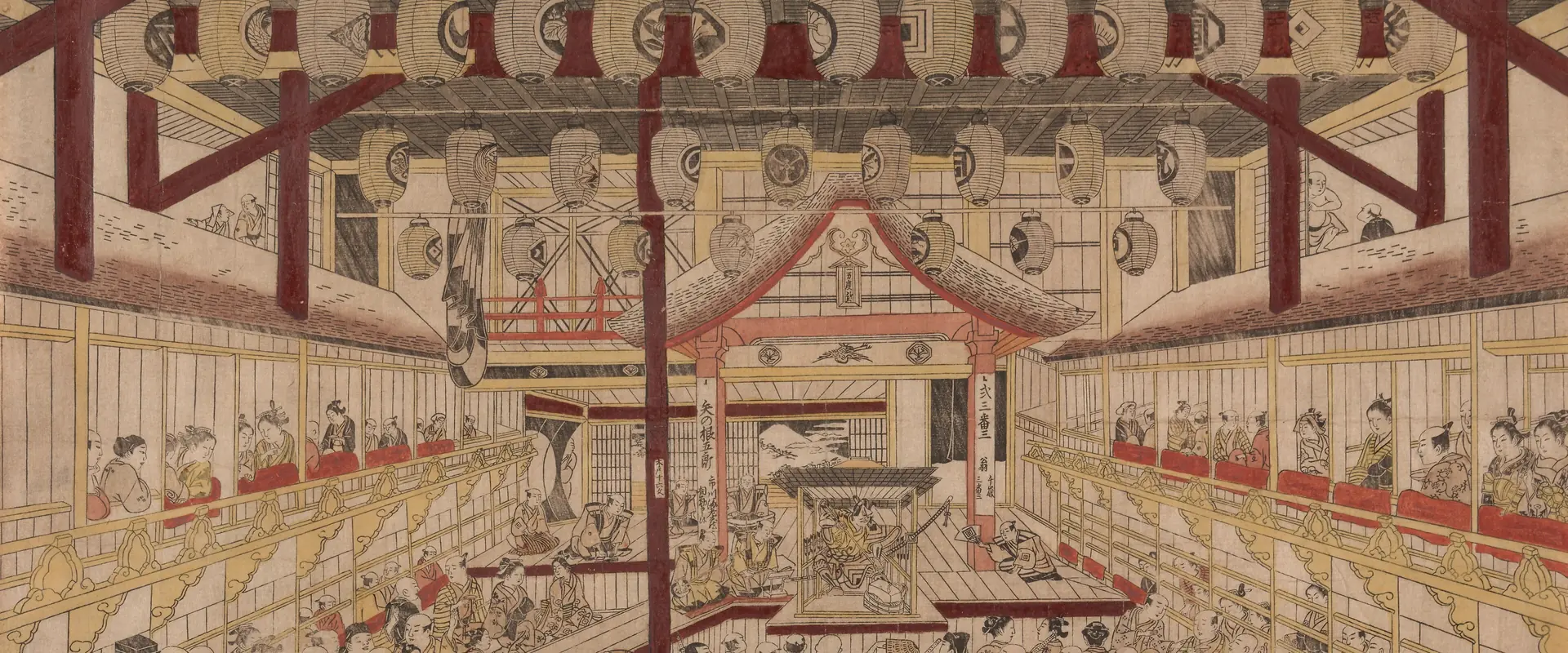 An Edo-period colour print looking down the length of a crowded kabuki theatre toward the stage, with boxes along both sides and lanterns overhead; an old print by Okumura Masanobu, not the venue
